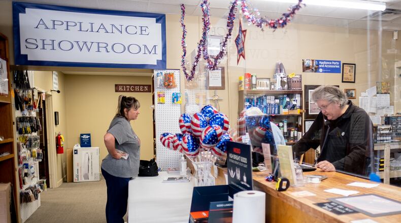 Vickie Mitchell, right, co-owner of Mitchell Appliance Company in Douglasville, talks to a customer on the phone as longtime customer Lori Brangan waits for a part to repair her dryer Thursday afternoon, Nov. 5, 2020. Mitchell said she is having a hard time getting appliances because the pandemic has slowed manufacturing. She also said that parts sales are up because people are repairing their current appliances more due to the shortage. Ben Gray / For the AJC