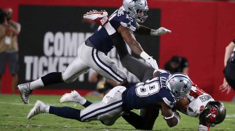 Tampa Bay Buccaneers tight end Rob Gronkowski (87) is taken down by Dallas Cowboys safety Damontae Kazee (18), bottom and linebacker Micah Parsons (11) during the first quarter at Raymond James Stadium, Thursday, Sept. 9, 2021, in Tampa, Florida. (Dirk Shadd/Tampa Bay Times/TNS)