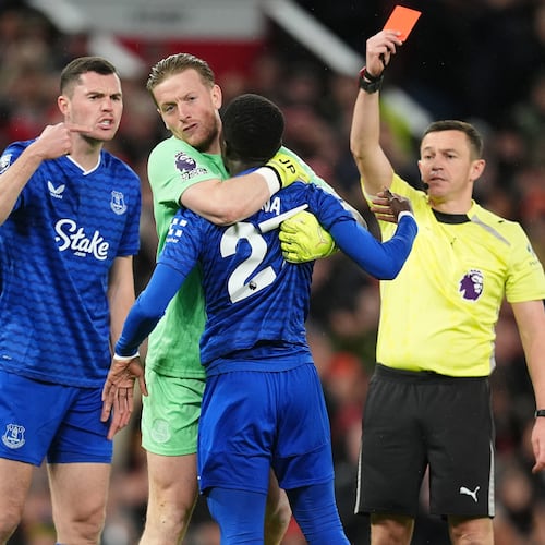 Everton's Idrissa Gueye, second right, is held back by teammate Jordan Pickford as he argues with Michael Keane, left, after getting a red card from referee Tony Harrington during the English Premier League soccer match between Manchester United and Everton in Manchester, England, Monday, Nov. 24, 2025. (Martin Rickett/PA via AP)