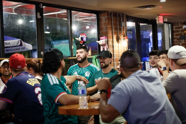 A group of customers watch a World Cup game on screens at Woofs Sport Bar. “You don’t have to worry about not being yourself (there),” says  Joshua Hill, the communications director for All Stripes, Atlanta United’s LGBTQ supporter group. (Miguel Martinez/AJC)
