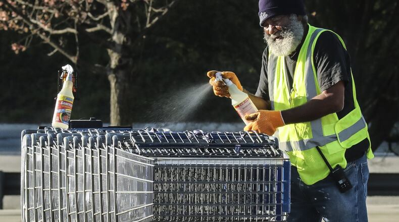 Sam’s Club workers sanitized shopping carts as customers lined up over the length of a football field at Sam’s Club located at 2901 Clairmont Rd in DeKalb County on Friday, April3, 2020. JOHN SPINK/JSPINK@AJC.COM