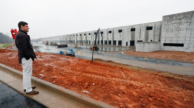 Adam Richards (left), co-founder of Reliant Real Estate Partners, stands in front of an Ellenwood distribution center under construction in December. South metro Atlanta has become a logistics powerhouse in metro Atlanta. BOB ANDRES /BANDRES@AJC.COM