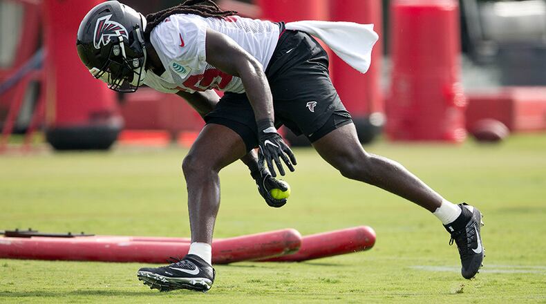 Atlanta Falcons outside linebacker De'Vondre Campbell (59) picks up a softball as he runs a drill during the team's NFL training camp football practice Friday, July 28, 2017, in Flowery Branch, Ga. (AP Photo/John Bazemore)
