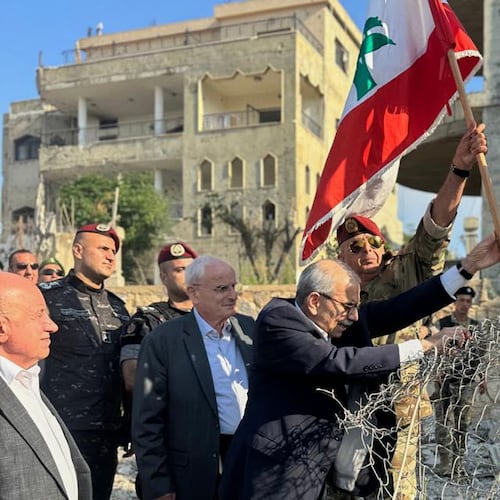 In this photo released by the Lebanese Government press office, Lebanese Prime Minister Nawaf Salam, center, raises a Lebanese flag during a visit to the southern village of Zawtar Al Gharbieh, Lebanon, Wednesday, July 22, 2026. (Lebanese Government press office via AP)