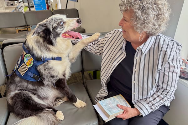 Hercules greets Janet Spry as she waits to board a flight Thursday, May 15, 2025, at West Virginia International Yeager Airport in Charleston, W.Va. (AP Photo/John Raby)