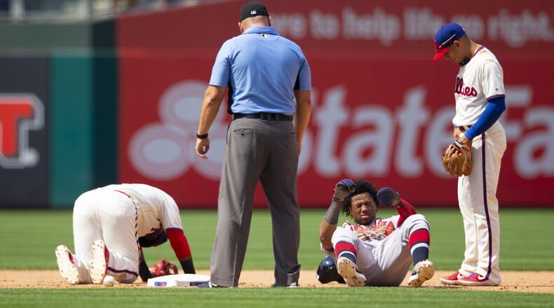 Umpire Mark Carlson and Phillies' Cesar Hernandez (right) check on Jean Segura (left) and Ronald Acuna after they collided in the top of the seventh inning July 28, 2019, at Citizens Bank Park in Philadelphia.