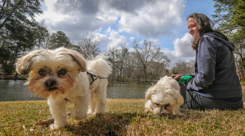 Vanessa Bolling brought her clients' dogs, Cookie (left) and Frosty, to the Duck Pond Park at Peachtree Heights East in Atlanta in this AJC file photo.