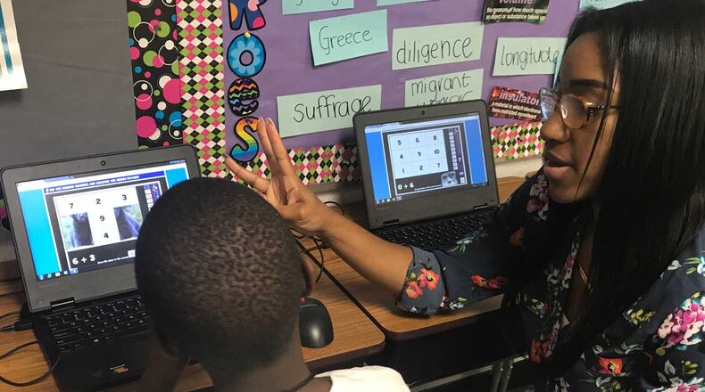 Tiana Thomas, a first-grade teacher at Gwinnett County's Jenkins Elementary School, works with a student as part of the school district's Math Institute. ERIC STIRGUS / ESTIRGUS@AJC.COM