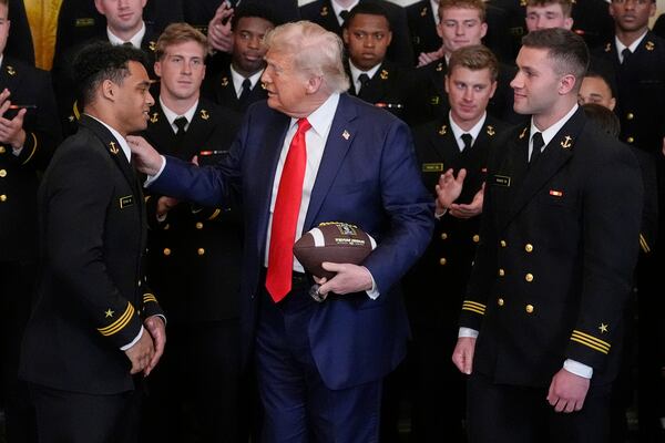 President Donald Trump talks with Daba Fofana, left, as Colin Ramos watches at the Commander-in-Chief trophy presentation to the Navy Midshipman football team in the East Room of the White House, Tuesday, April 15, 2025, in Washington. (AP Photo/Alex Brandon)