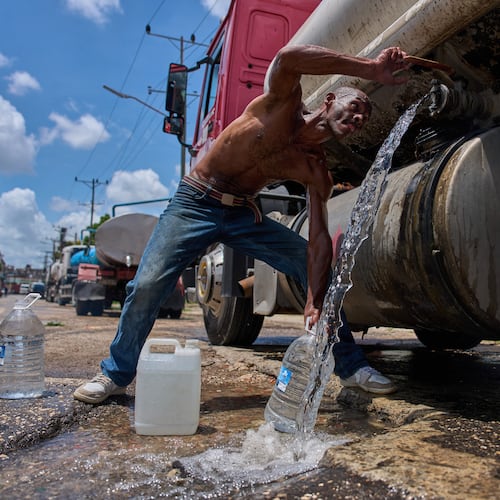 A man fills water jugs from a tanker truck in Havana, Thursday, May 28, 2026. (AP Photo/Ramon Espinosa)