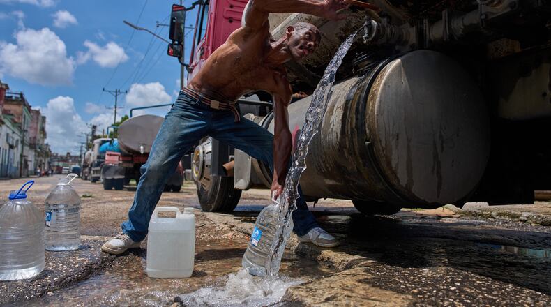 A man fills water jugs from a tanker truck in Havana, Thursday, May 28, 2026. (AP Photo/Ramon Espinosa)