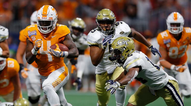ATLANTA, GA - SEPTEMBER 04:  John Kelly #4 of the Tennessee Volunteers rushes against Corey Griffin #14 and A.J. Gray #5 of the Georgia Tech Yellow Jackets at Mercedes-Benz Stadium on September 4, 2017 in Atlanta, Georgia.  (Photo by Kevin C. Cox/Getty Images)