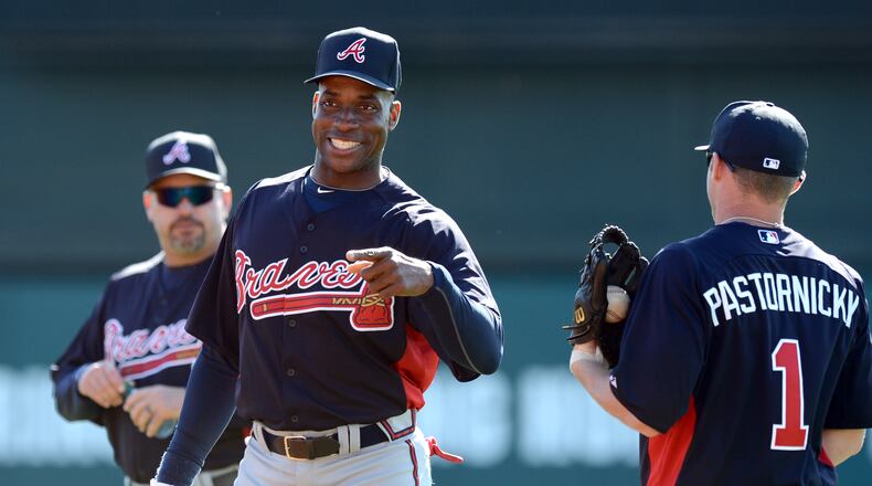 Former Braves first baseman Fred McGriff smiles as he talks with infielder Tyler Pastornicky during spring training in 2013. HYOSUB SHIN / HSHIN@AJC.COM