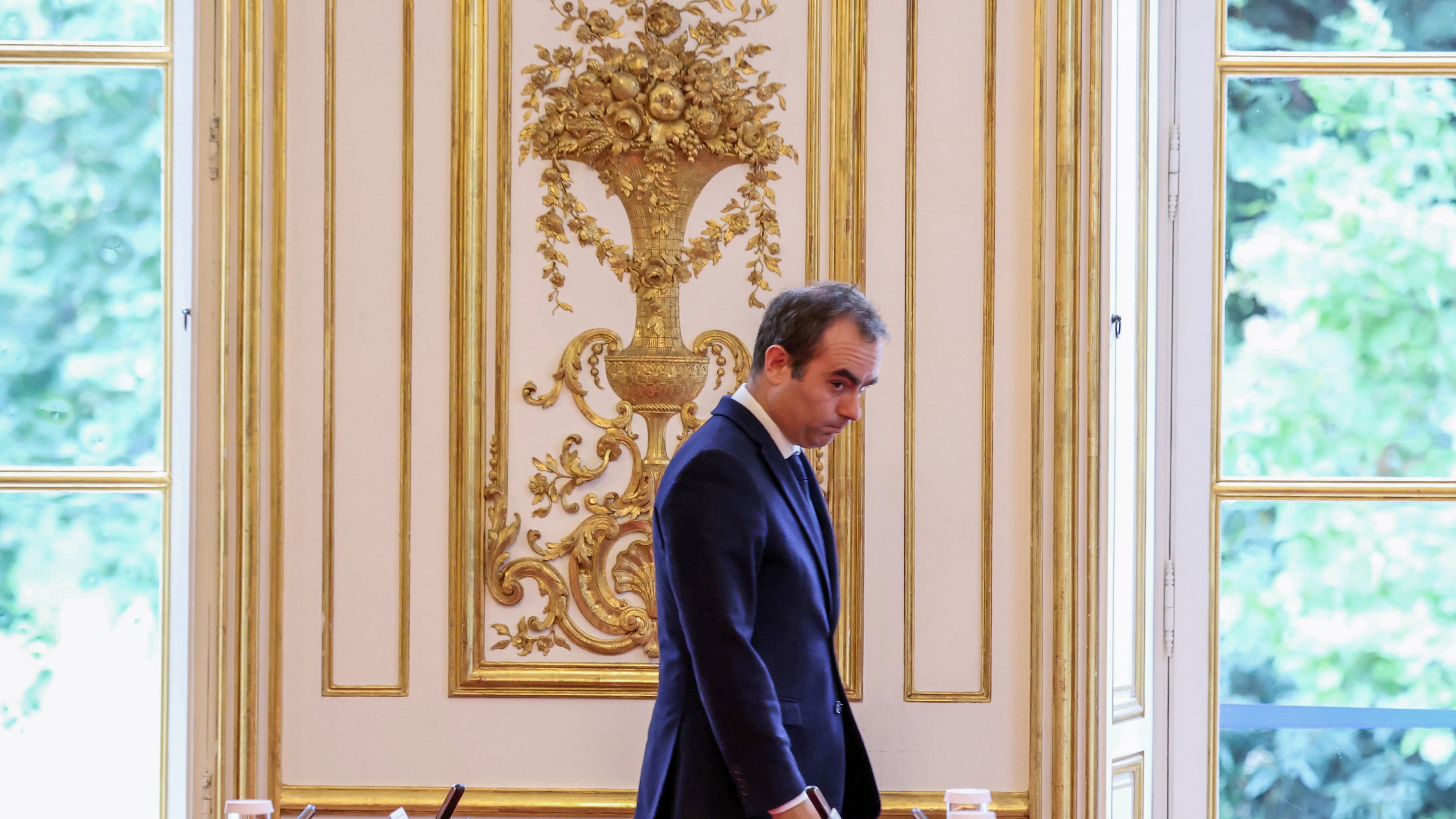 France's reappointed Prime Minister Sebastien Lecornu walks past a meeting table as he welcomes the newly-appointed members of his cabinet in Paris, Monday, Oct. 13, 2025. (Alain Jocard, Pool photo via AP)