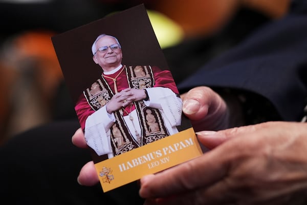 Grace Mellor prays as she holds a brochure that reads "A prayer of thankfulness for the election of Pope Leo XIV" during a mass at Holy Name Cathedral in Chicago, Sunday, May 11, 2025. (AP Photo/Nam Y. Huh)