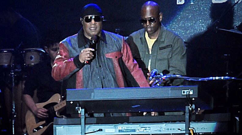 Musician Stevie Wonder, front left, and comedian Dave Chappelle appear on stage during the "Gem City Shine," event in the Oregon District in Dayton, Ohio, Sunday, Aug. 25, 2019.