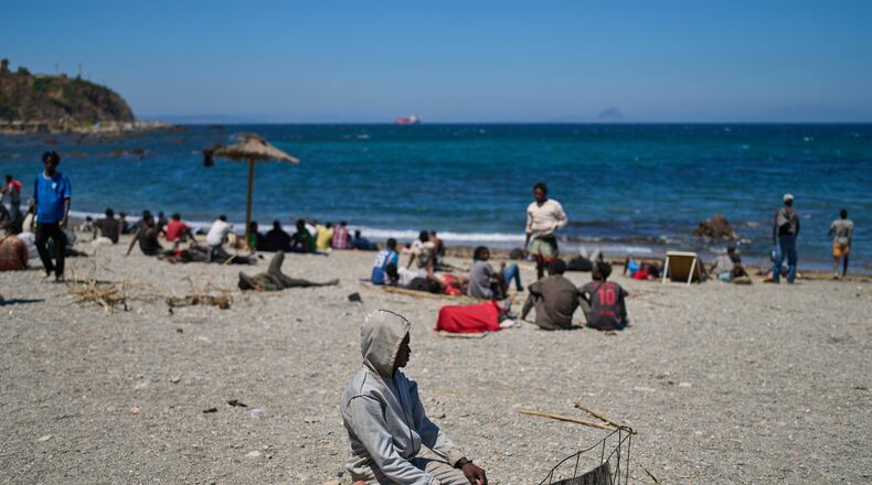 A migrant who crossed into Spain from Morocco prays on a beach in the Spanish enclave of Ceuta, Sunday, Aug. 2, 2026. (AP Photo/Bernat Armangue)