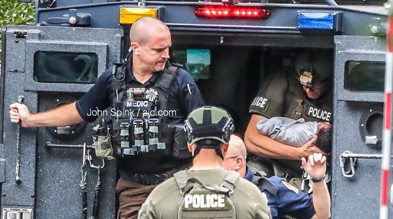 A SWAT officer cradles a baby removed from a Gwinnett County apartment during a standoff with the child's father Thursday morning.