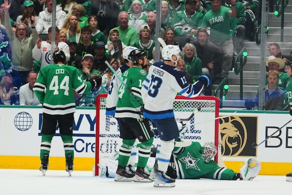 Winnipeg Jets' Gabriel Vilardi (13) celebrates a goal scored by Kyle Connor, standing nearby, as Dallas Stars goaltender Jake Oettinger (29) lies on the ice after the score in the first period of Game 3 of a second-round NHL hockey playoff series in Dallas, Sunday, May 11, 2025. (AP Photo/Julio Cortez)
