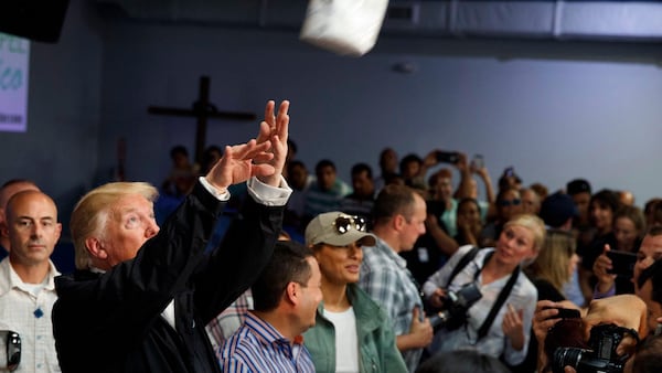 President Donald Trump tosses paper towels into a crowd as he hands out supplies to people affected by Hurricane Maria at Calvary Chapel, Tuesday, Oct. 3, 2017, in Guaynabo, Puerto Rico. (Evan Vucci/AP)