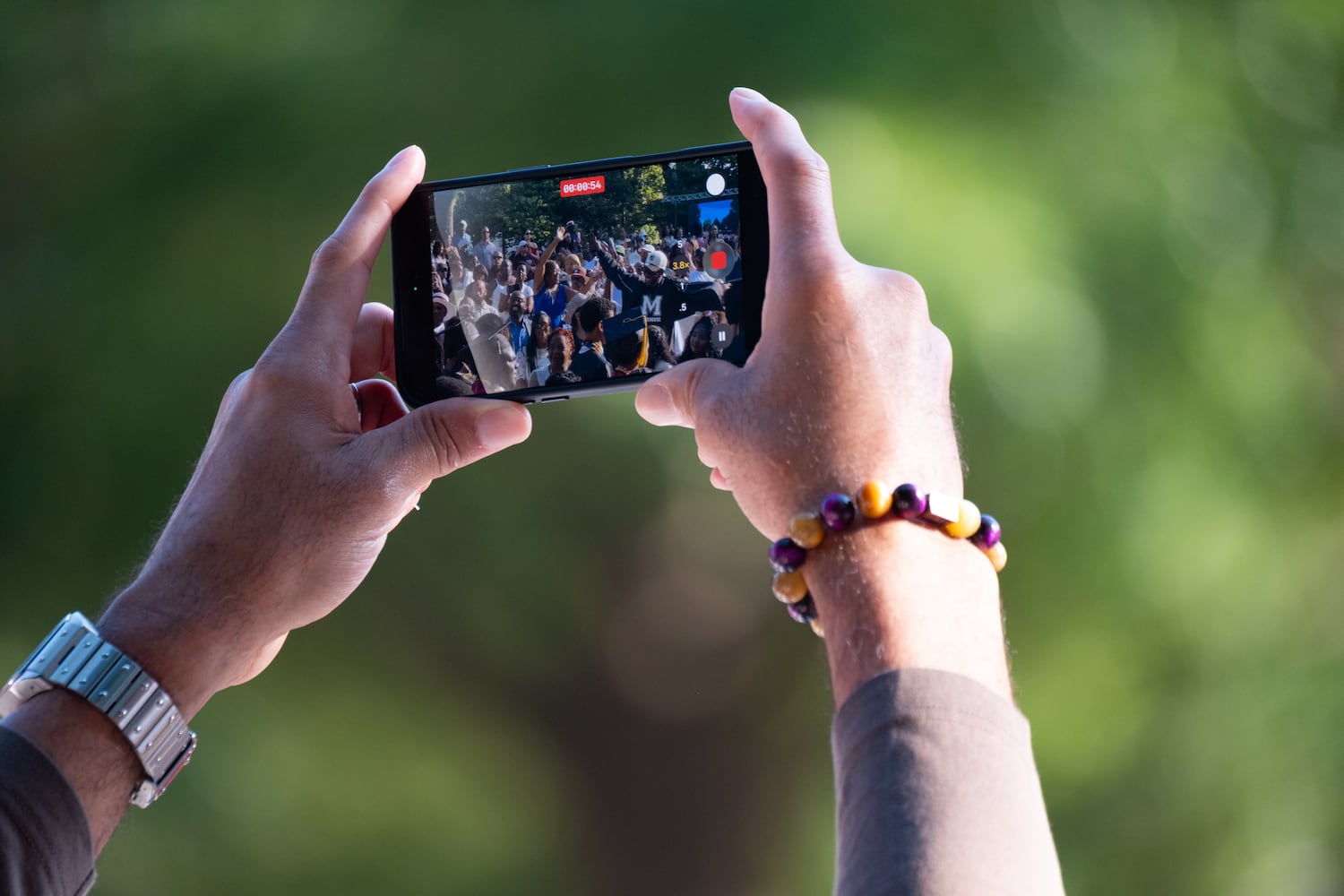 A person shoots video of students in the procession to the Morehouse College graduation Sunday, May 17, 2026. (Ben Gray for the AJC)