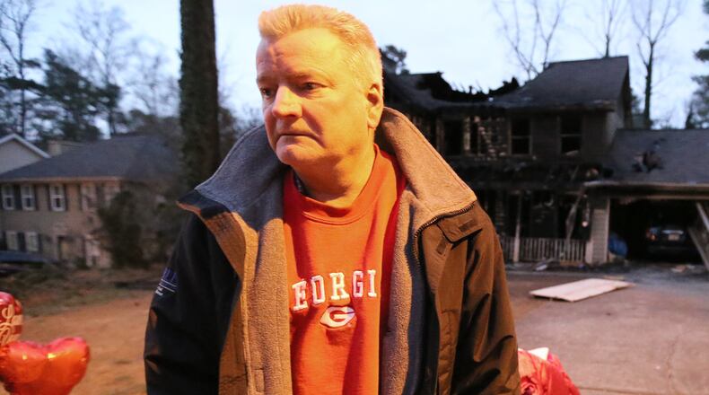 Brent Patterson stands in front of his burned-out Tucker home on Wednesday night Feb. 10, 2016, following a Tuesday night fire that killed his wife and two daughters. Ben Gray / bgray@ajc.com