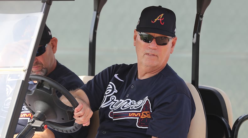 Braves manager Brian Snitker takes in the scene from his golf cart early in spring training.