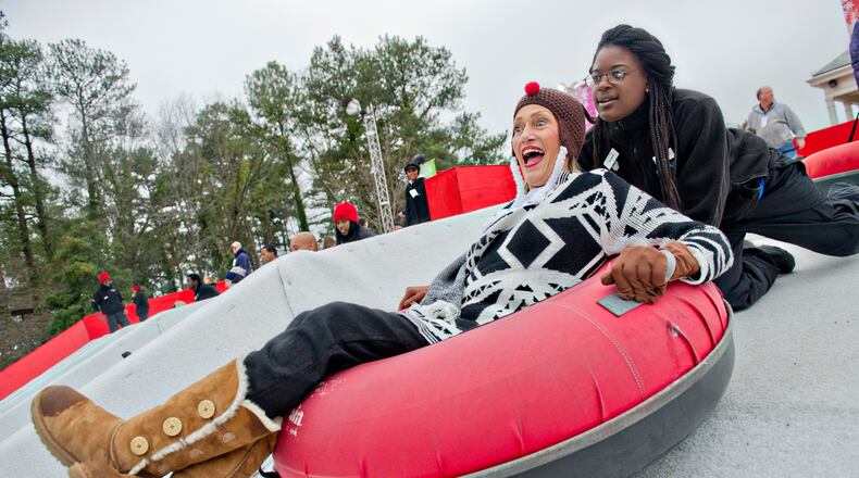 SNOW MOUNTAIN--December 21, 2014 Stone Mountain - Vicki Everage (left) screams as Tamara Mitchell pushes her tube down the hill during Snow Mountain at Stone Mountain Park on Sunday, December 21, 2014. This is the seventh season that the main lawn at the park has been transformed into a winter wonderland. JONATHAN PHILLIPS / SPECIAL
