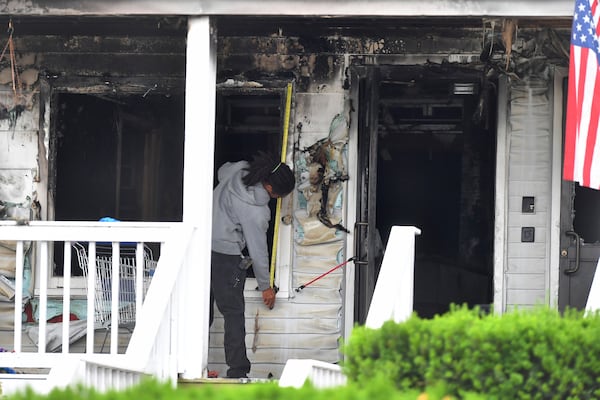An investigator takes measurements Monday, July 14, 2025, near an entrance to the Gabriel House assisted living facility following a fire that started late Sunday in Fall River, Mass. (AP Photo/Steven Senne)