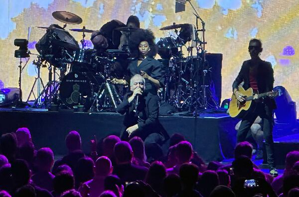 Jim Kerr of Simple Minds in squat mode during his appearance at Synovus Bank Amphitheater at Chastain Park in Atlanta on Saturday. (Rodney Ho/AJC)
