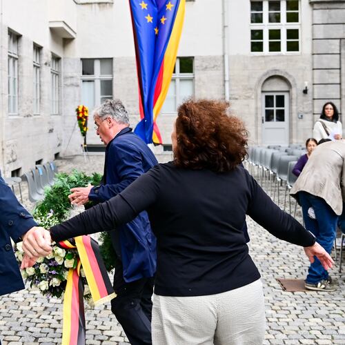 Tobias Korenke, center, grandnephew of Dietrich and Klaus Bonhoeffer and grandson of Ruediger Schleicher, try to remove a wreath of Germany's far right AFD party during a memorial event held by the federal government in the courtyard of the Bendlerblock of the Defence Ministry in occasion of the National Day of Remembrance for Resistance Against Nazi regime in Berlin, Monday, July 20, 2026. (Sebastian Christoph Gollnow/dpa via AP)