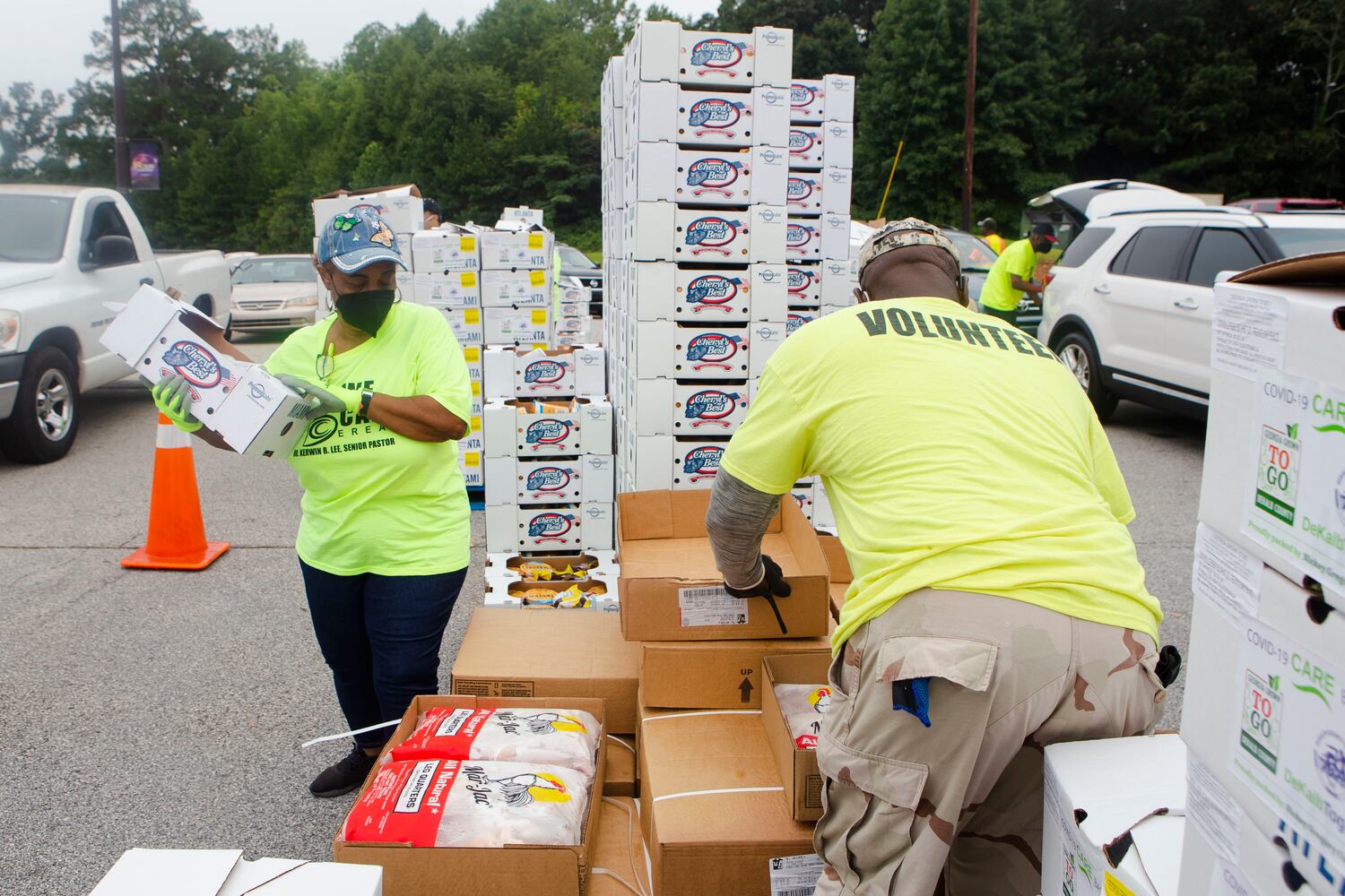Valerie Henry (left) and Bernard Williams (right) volunteer during a food giveaway event at Berean Christian Church on Saturday, August 27, 2022, in Stone Mountain, Georgia.  The free food was paid for using federal COVID-19 stimulus funds, and was distributed at churches throughout DeKalb County. CHRISTINA MATACOTTA FOR THE ATLANTA JOURNAL-CONSTITUTION.