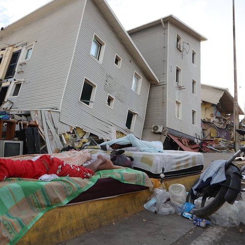 A boy sleeps outside earthquake-damaged homes in Catia La Mar, Venezuela, Sunday, June 28, 2026. (AP Photo/Pedro Mattey)