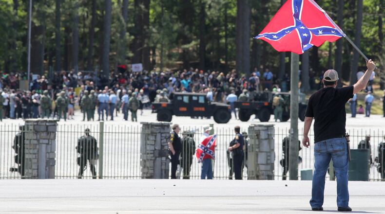 MOUNTAIN OF PROTEST--April 23, 2016 Stone Mountain: Joseph Andrews, one of a small group with the Rock Stone Mountain rally, waves a confederate battle flag towards a mass of counter-protesters more than 100 yards away at Stone Mountain Park on Saturday afternoon April 23, 2016 where a white power protest and two counter protests were scheduled. Ben Gray / bgray@ajc.com