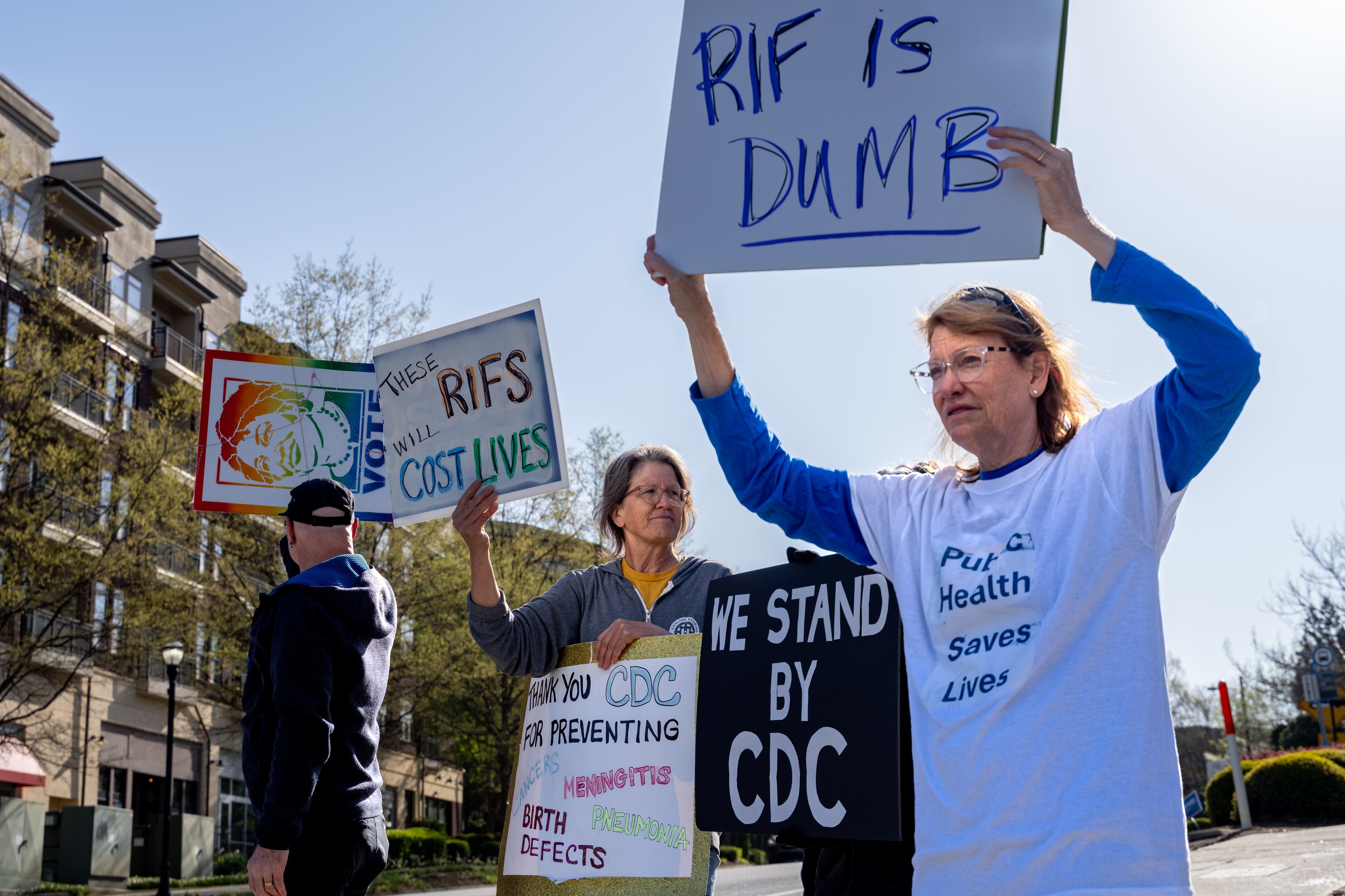 Barbara Marston (right), a former employee at the Centers for Disease Control and Prevention, protests the reductions in force and budget cuts at the CDC in Atlanta in April. As he runs for reelection, Atlanta Mayor Andre Dickens may find it a challenge to explain how President Donald Trump's policies have impacted the city's progress. (Ben Hendren for the AJC 2025)