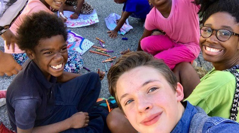 Aidan Anderson takes a selfie with kids at Adopt-a-Block, one of the causes to which the 16-year-old gives his time. CONTRIBUTED BY TOREN ANDERSON