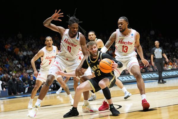 Purdue's Braden Smith (3) handles the ball as Houston's Milos Uzan (7), Joseph Tugler (11) and J'Wan Roberts (13) defend during the first half in the Sweet 16 of the NCAA college basketball tournament Friday, March 28, 2025, in Indianapolis. (AP Photo/AJ Mast)