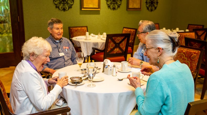Residents at Canterbury Court including Marguerite Wellborn and her husband Marshall Wellborn, from left, finish up their lunch with Greg and Nancy Fukushima at the long-term facility’s cafeteria Wednesday, June 16, 2021.  Residents were quarantined to their rooms with all meals delivered at the height of Covid and now staff is 100% fully vaccinated and residents go without masks; while staff, despite full vaccination, continues to wear masks while they are at work at the facility.  Activity calendars are posted and social events, including Father’s Day visits are happening at the retirement facility.  (Jenni Girtman for The Atlanta Journal Constitution)