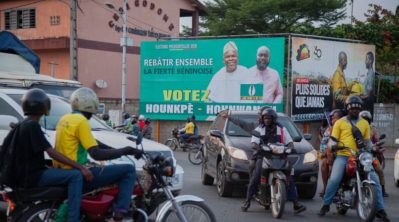 Road users pass in front of a campaign billboard for presidential candidate Paul Hounkpe and his running mate, Rock Hounwanou in Cotonou, Benin, Friday, April 10, 2026. (AP Photo/Abadjaye Justin Sodogandji)