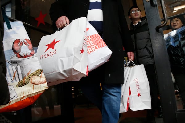 FILE - Shoppers leave Macy's in Boston, Nov. 29, 2019. (AP Photo/Michael Dwyer, file)