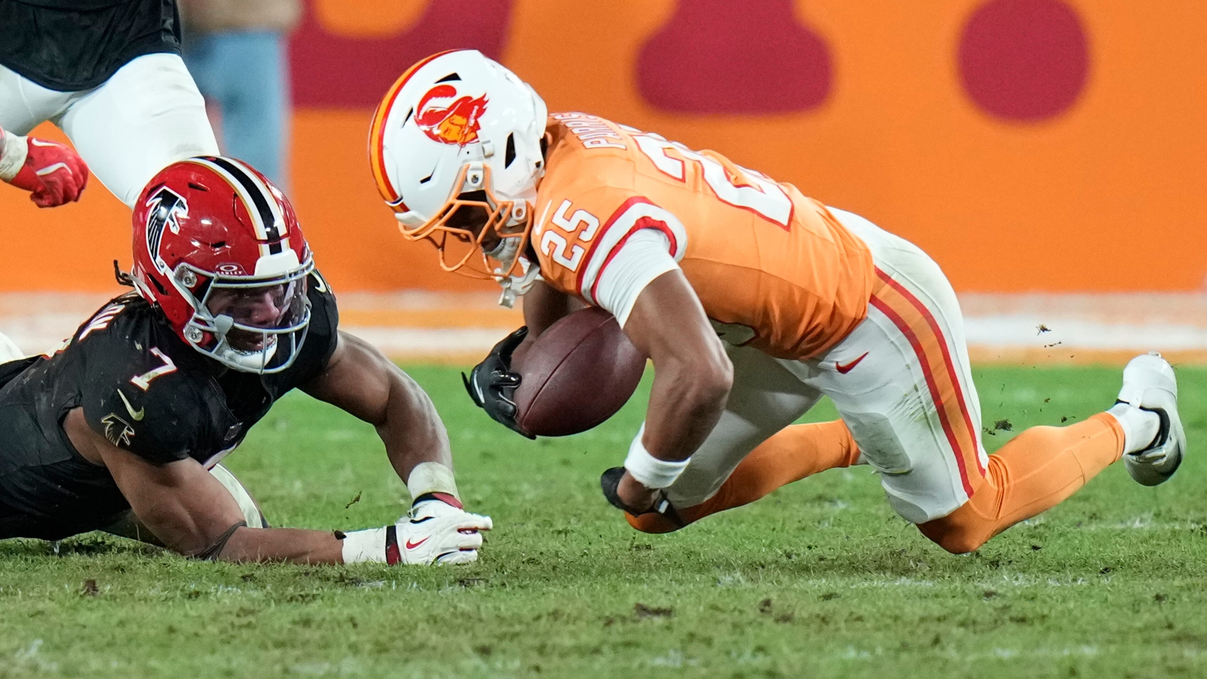 Tampa Bay Buccaneers cornerback Jacob Parrish (25) recovers a fumble by Atlanta Falcons running back Bijan Robinson (7) during the second half of an NFL football game, Thursday, Dec. 11, 2025, in Tampa, Fla. (AP Photo/Chris O'Meara)