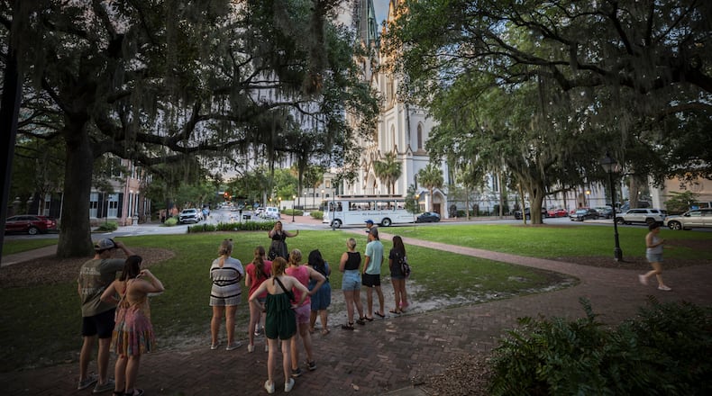 SAVANNAH, GA - MAY 28, 2024: A tour guide starts a walking tour at Lafayette Square with the historic Cathedral Basilica of St. John the Baptist as a backdrop, Tuesday, May 28, 2024, in Savannah, Ga. With city's tourism surge affecting residents quality of life, elected leaders are exploring limits on trolley, horse carriage and walking tours. (AJC Photo/Stephen B. Morton)