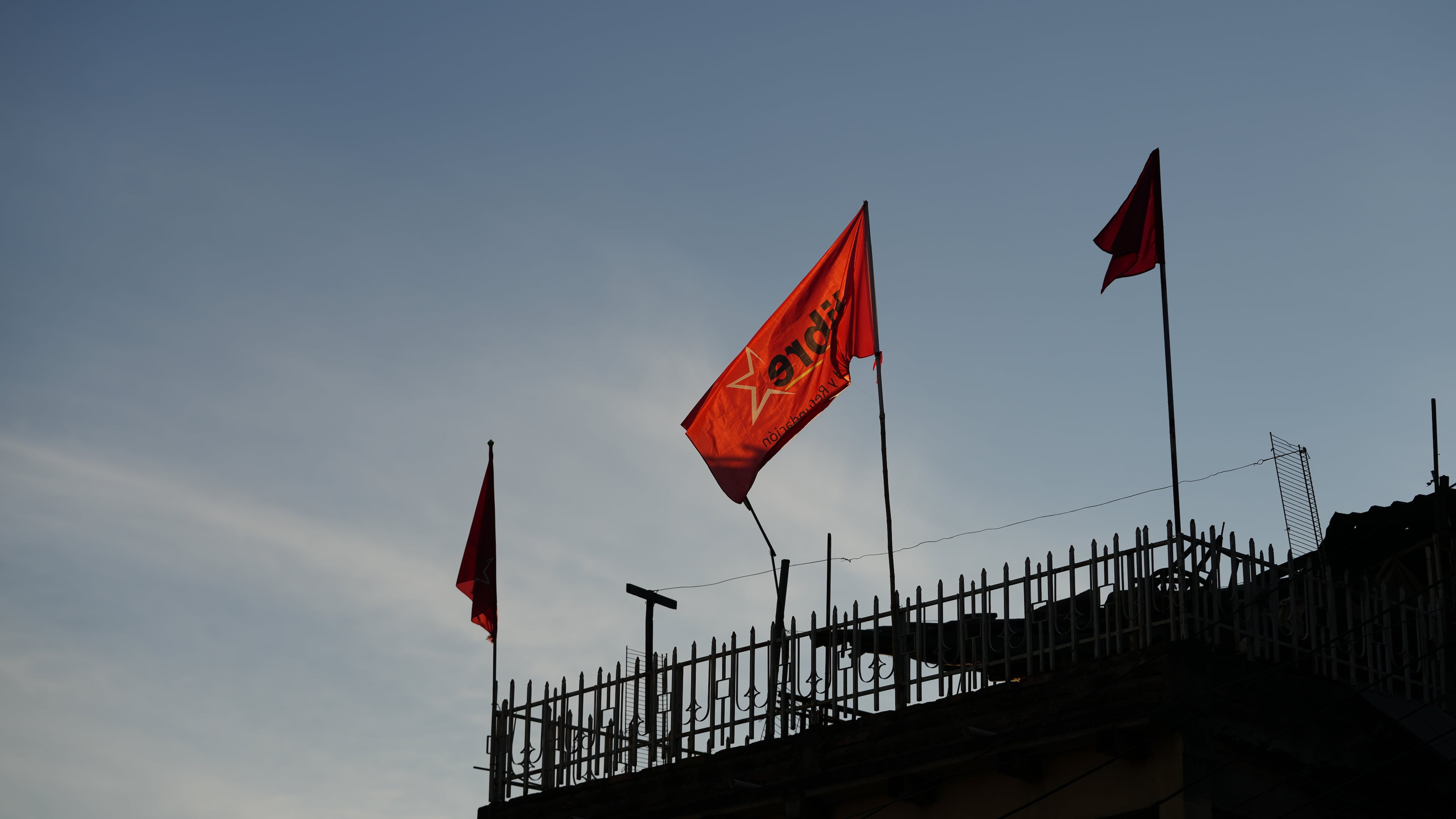 Flags of the ruling party LIBRE, Liberty and Refoundation, fly on a home's roof in Tegucigalpa, Honduras, Tuesday, Dec. 2, 2025. (AP Photo/Moises Castillo)