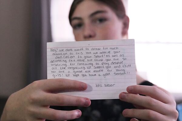 Parker Tirrell, a transgender athlete who plays on her high school's girls soccer team, holds up an inspiring note she received from a visiting team, Friday, March 7, 2025, in Plymouth, N.H. (AP Photo/Charles Krupa)