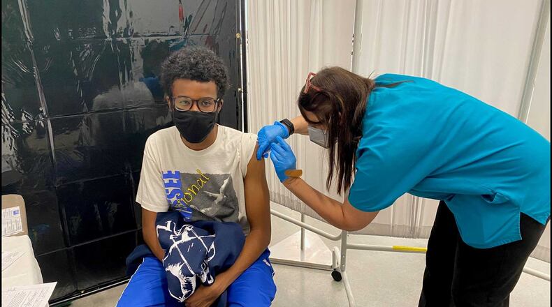 Georgia Tech nurse Melanie Thomas administers a COVID-19 vaccine shot to student Grayson Prince at its Exhibition Hall on July 20, 2021. The school has been doing vaccinations on Tuesdays this summer for students and employees. (Eric Stirgus / estirgus@ajc.com)