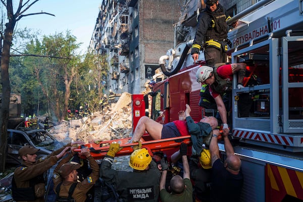 Rescue workers evacuates an injured man from a multi-storey residential house destroyed by a Russian strike in Kyiv, Ukraine, on Tuesday, June 17, 2025. (AP Photo/Evgeniy Maloletka)