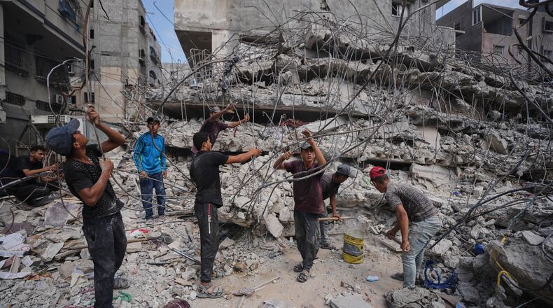 Palestinians remove iron from the rubble of buildings destroyed by Israeli airstrikes during the war with Hamas, repair and recycle it for construction, building tents or selling it, in Gaza City, Sunday, Aug. 16, 2026. (AP Photo/Jehad Alshrafi)