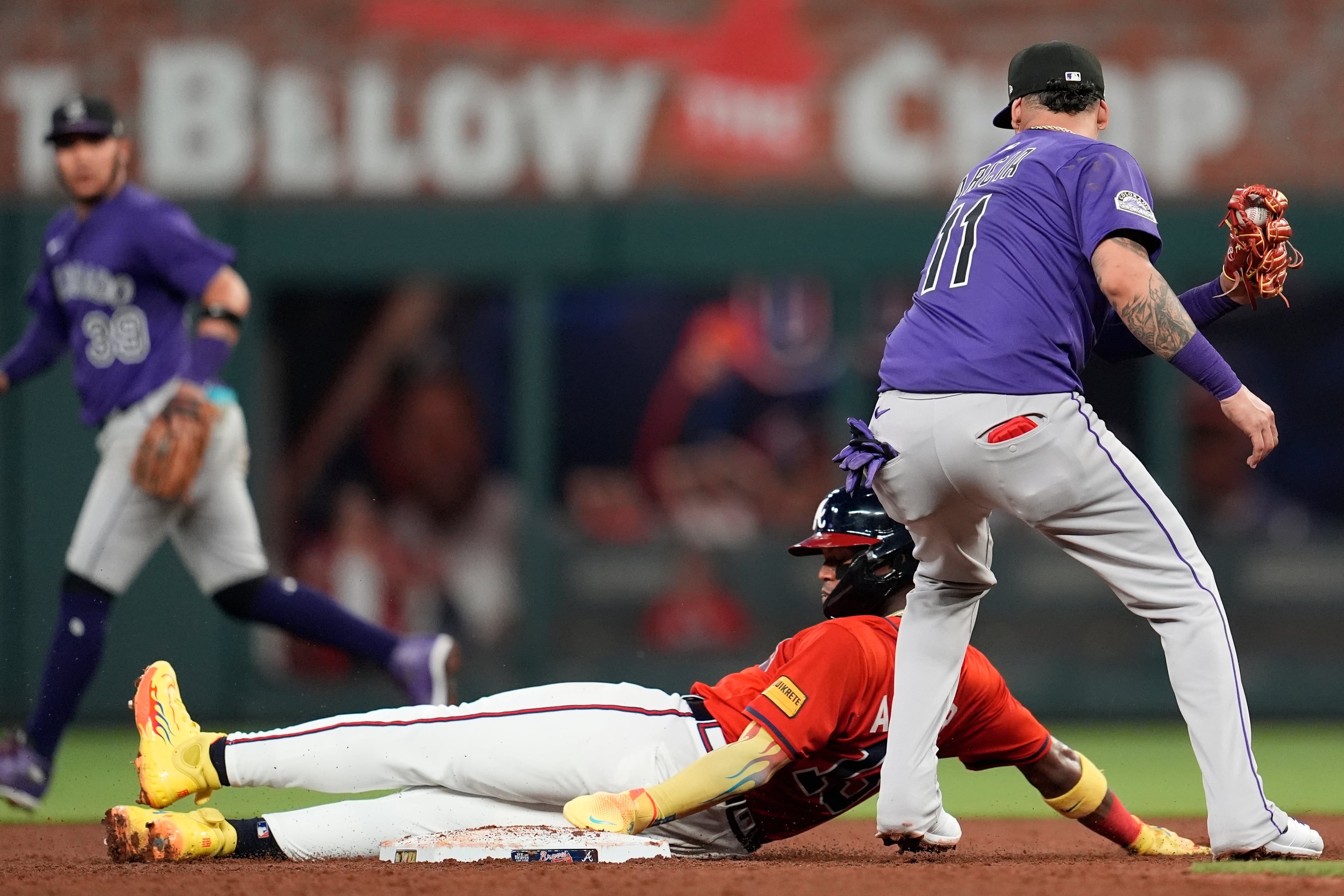 The Braves' Ronald Acuña Jr. steals second base against Rockies shortstop Orlando Arcia during the fifth inning Friday in Atlanta. (Mike Stewart/AP)