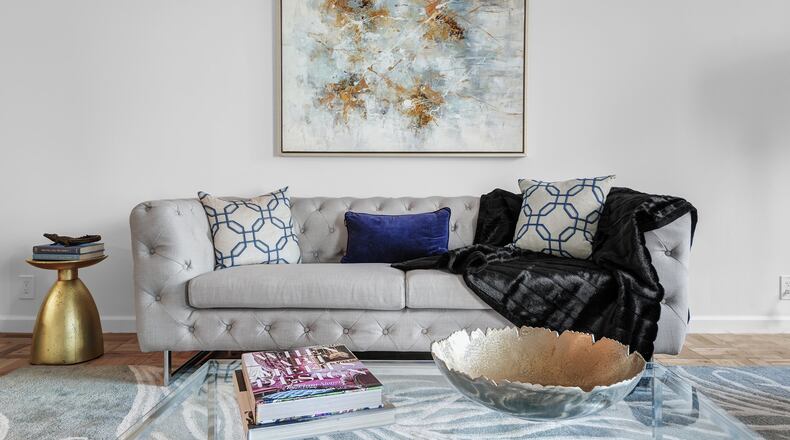 A piece of art and area rug help infuse pastel colors into this living space. (Design Recipes)