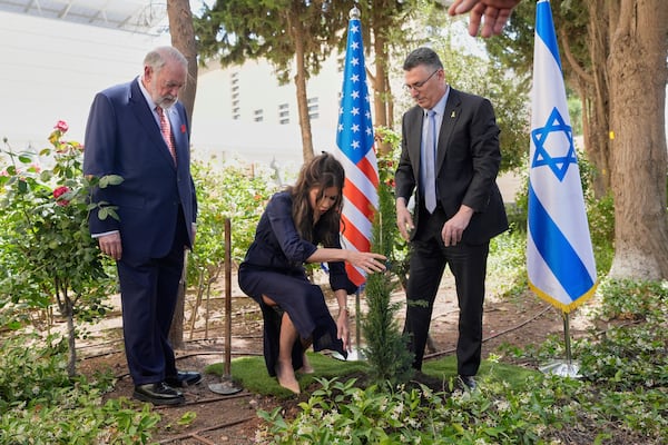 U.S. Homeland Security Secretary Kristi Noem, center, and Israel's Foreign Minister Gideon Sa'ar, right, plant a tree as U.S. Ambassador to Israel Mike Huckabee looks on, in Jerusalem, Monday, May 26, 2025. (AP Photo/Alex Brandon, Pool)